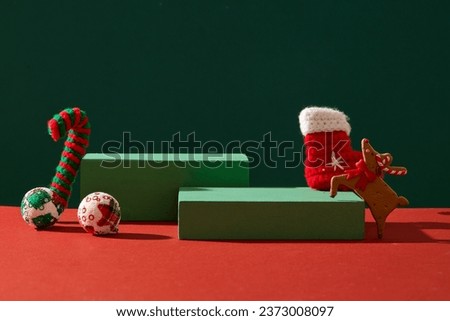 Advertising scene with Christmas concept. Green empty podiums decorated with cute woolen accessory on green and red background. Front view, space for design