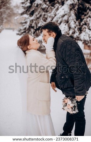 Winter wedding. Newlyweds walking outdoors at winter time