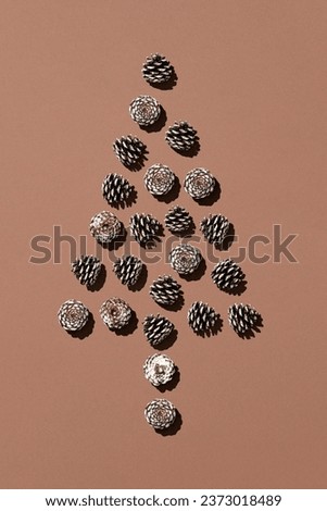 Pine cones arranged as pine tree on brown background