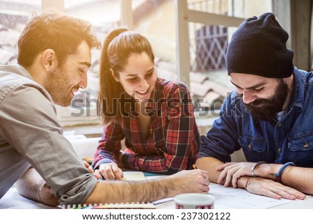 Teamwork. Three young architects working on a project Royalty-Free Stock Photo #237302122