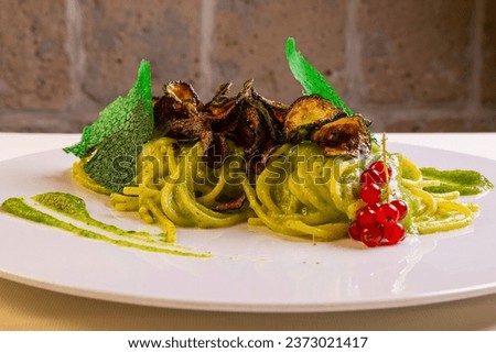 Spaghetti alla Nerano with courgette cream, provolone del monaco and fried courgettes served in an elegant restaurant Royalty-Free Stock Photo #2373021417