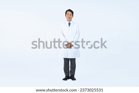 Standing middle aged Asian doctor. Royalty-Free Stock Photo #2373025531