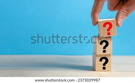 Question Mark concept. Hand holding question mark on wooden cube block.