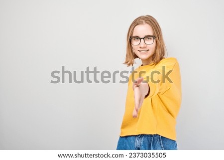 Portrait of confident student girl chooses you points finger at camera isolated on white studio background. Welcome gesture, join our team concept