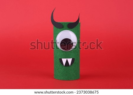 Spooky monster on red background. Handmade Halloween decoration