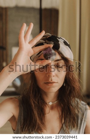 Woman holding natural stone, relaxed with closed eyes. Mindful meditation concept. Wellbeing. No focus blurred and noise effect. Spirituality, religion, God concept.