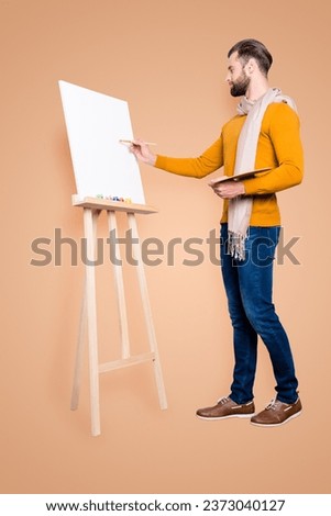 Full size fullbody portrait of busy creative artist with scarf around neck, hairstyle, in jeans, sweater, holding colorful palette and drawing a picture, isolated on grey background