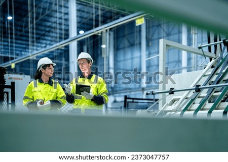 male and female technician engineers checking the process on Heavy machine. mechanical engineering team production. Industry manufacturing. Worker holding tablet and folde. High technology production. Royalty-Free Stock Photo #2373047757