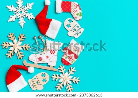 Top view of Christmas decorations and Santa hats on blue background. Happy holiday concept with copy space.