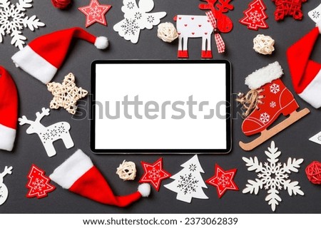 Top view of digital tablet. New Year decorations on black background. Merry Christmas concept.