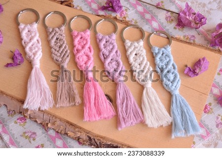 Macrame key chains wood background diy handmade hobby small gifts, wedding guest favors colorful rustic vintage boho style souvenirs, beautiful artisan presents, small home business, sell online Royalty-Free Stock Photo #2373088339