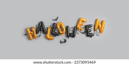 Word HALLOWEEN made of balloons on grey background