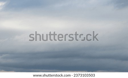 Autumn brings overcast skies adorned with gray stratus clouds, hinting at impending rain. This full-screen view provides ample space for text or design elements, making it perfect for various projects Royalty-Free Stock Photo #2373103503