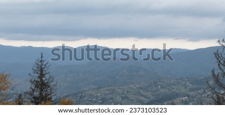 Autumn brings overcast skies adorned with gray stratus clouds, hinting at impending rain. This full-screen view provides ample space for text or design elements, making it perfect for various projects Royalty-Free Stock Photo #2373103523
