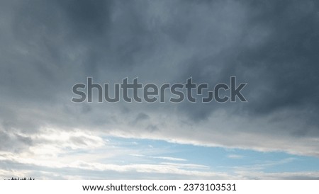 Autumn brings overcast skies adorned with gray stratus clouds, hinting at impending rain. This full-screen view provides ample space for text or design elements, making it perfect for various projects Royalty-Free Stock Photo #2373103531