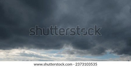 Autumn brings overcast skies adorned with gray stratus clouds, hinting at impending rain. This full-screen view provides ample space for text or design elements, making it perfect for various projects Royalty-Free Stock Photo #2373103535