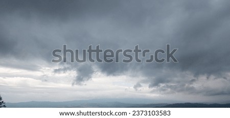 Autumn brings overcast skies adorned with gray stratus clouds, hinting at impending rain. This full-screen view provides ample space for text or design elements, making it perfect for various projects Royalty-Free Stock Photo #2373103583