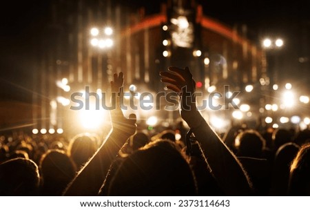 Applause for an artist's performance at a music concert. Raised hands silhouette close-up