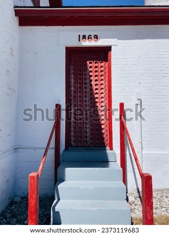 A picture of a red door and a white wall