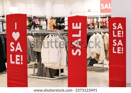 Sale banner at clothing store entrance. Seasonal discount offer in store