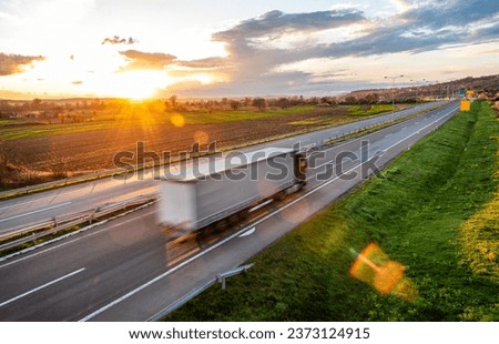 Fast blurred highway traffic. Transportation truck in high speed driving on a highway through rural landscape. Fast blurred motion drive on the freeway. Freight scene on the motorway Royalty-Free Stock Photo #2373124915