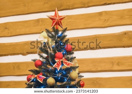 New Year's Christmas holiday green tree decorated toys balloons ribbons on wooden background.