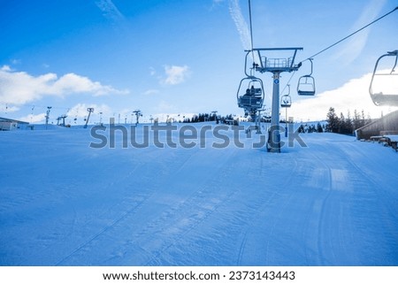 A beautiful view of winter resort with a cable car on mountain under blue cloudy sky