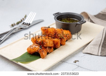 Slices of pike perch in sweet and sour sauce on a banana leaf