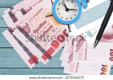 100 Thai Baht bills and alarm clock with pen and envelopes. Tax season concept, payment deadline for credit or loan. Financial operations using postal service. Quick money transfer Royalty-Free Stock Photo #2373160175