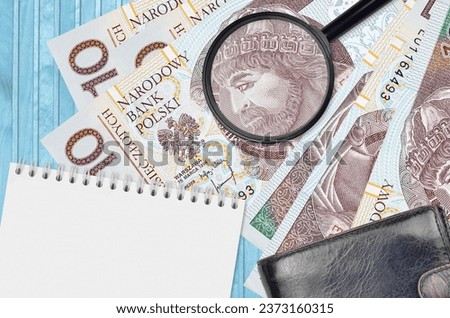 10 Polish zloty bills and magnifying glass with black purse and notepad. Concept of counterfeit money. Search for differences in details on money bills to detect fake money
