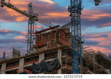 Cranes construction site moody sunset sky stock photo