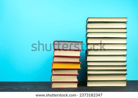Books on wooden table, on a blue background. Back to school. Copy space for text. Education background
