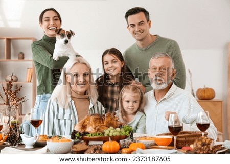 Happy family having dinner at festive table on Thanksgiving Day