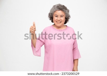 Asian senior woman smile and showing thumbs up and looking at camera isolated on white background