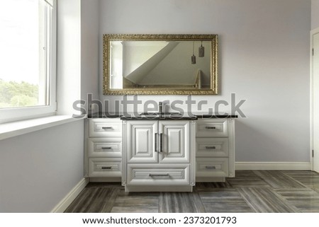 A modern bathroom with a bathroom, including a wall mirror and a sink above a wooden stand and a closet. Royalty-Free Stock Photo #2373201793
