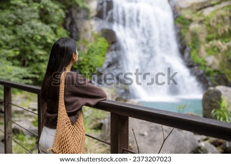Woman look at the beautiful waterfall