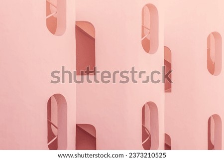 Abstract modern architecture background. Fragment of contemporary facade walls cement building. pattern balconies windows detail. Geometric clear pink building design. multi window and empty balcony Royalty-Free Stock Photo #2373210525