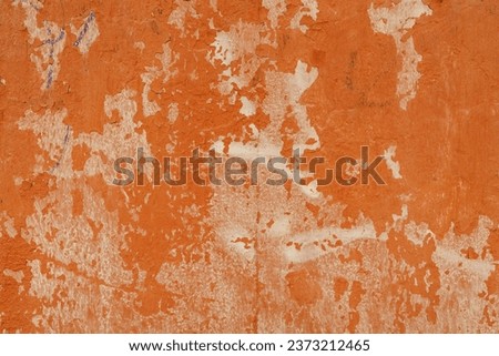 A cement wall painted red with the paint worn away Royalty-Free Stock Photo #2373212465