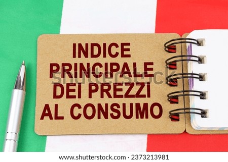 Economy and finance concept. On the flag of Italy lies a pen and a notebook with the inscription - core consumer price index. Text in Italian. Royalty-Free Stock Photo #2373213981