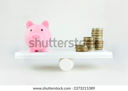Close-up Of Balancing Stacked Of Coins Money and pink pig spear On on white background. Balancing time and money