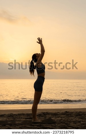 lady stretching with sport clothes next to the beach in the mornig