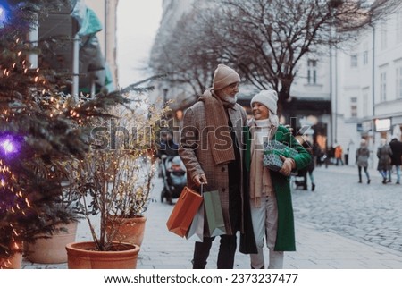 Happy senior couple buying christmas gifts in the city.
