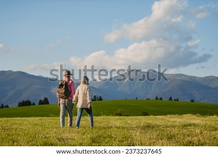 Senior couple walking through the autumn nature with beautiful view of the High Tatras. Minimalist landscape photography with copy space.