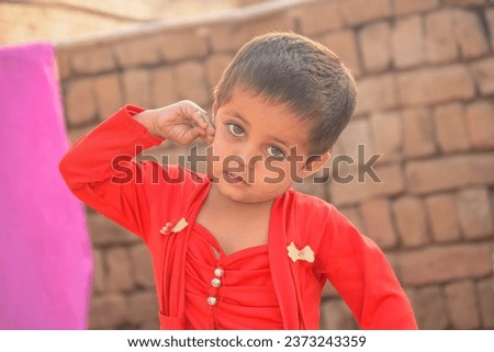 Portrait of beautiful Pakistani kid laughing. Beautiful Pakistani kid beautifully posing against blurred background. Asian kid. Kid model photography.  Village baby girl from Punjab Pakistan. 