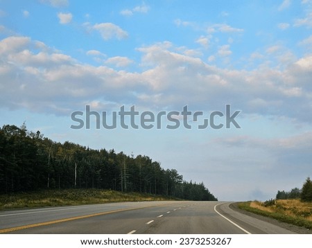 A wide open highway through a rural area on a summer morning.