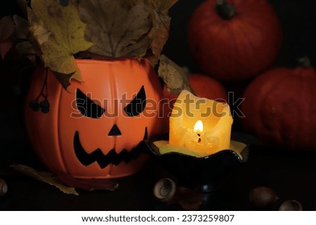 Happy Halloween. A plastic pumpkin bucket with an evil smile. Halloween horror concept. Ripe pumpkins in candlelight, horror concept, Halloween holiday