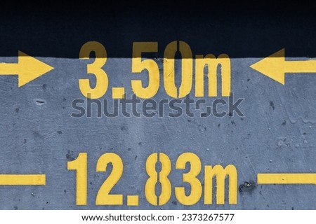 meter signs with numbers in yellow color on old dirty wall