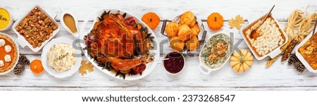 Delicious Thanksgiving turkey dinner. Top view table scene on a rustic white wood banner background. Turkey, mashed potatoes, stuffing, pumpkin pie and sides. Royalty-Free Stock Photo #2373268547