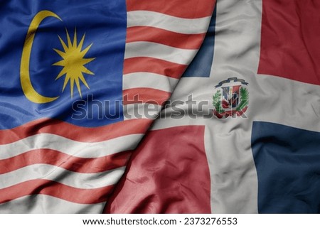 big waving realistic national colorful flag of malaysia and national flag of dominican republic . macro