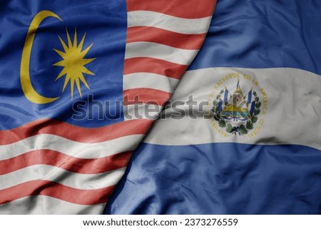 big waving realistic national colorful flag of malaysia and national flag of el salvador . macro